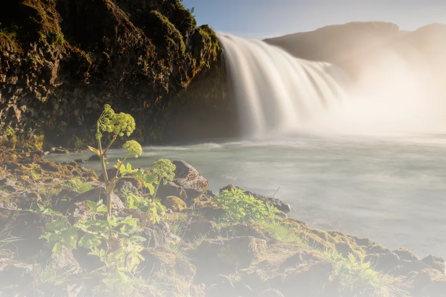 A printed page mock-up: a photograph of a waterfall above a caption reading The road east.